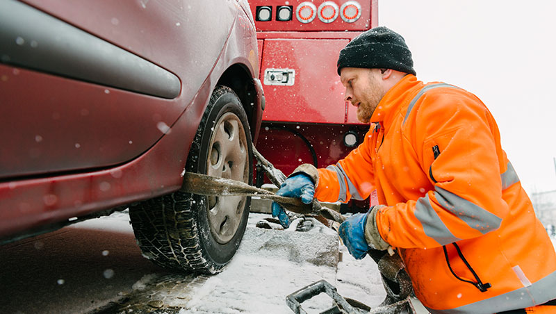 A car maintainance guy trying to put a belt around tyre